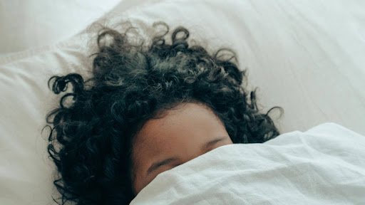 A kid is sleeping peacefully in her favourite white bedding & duvet cover in cold seasons of UK